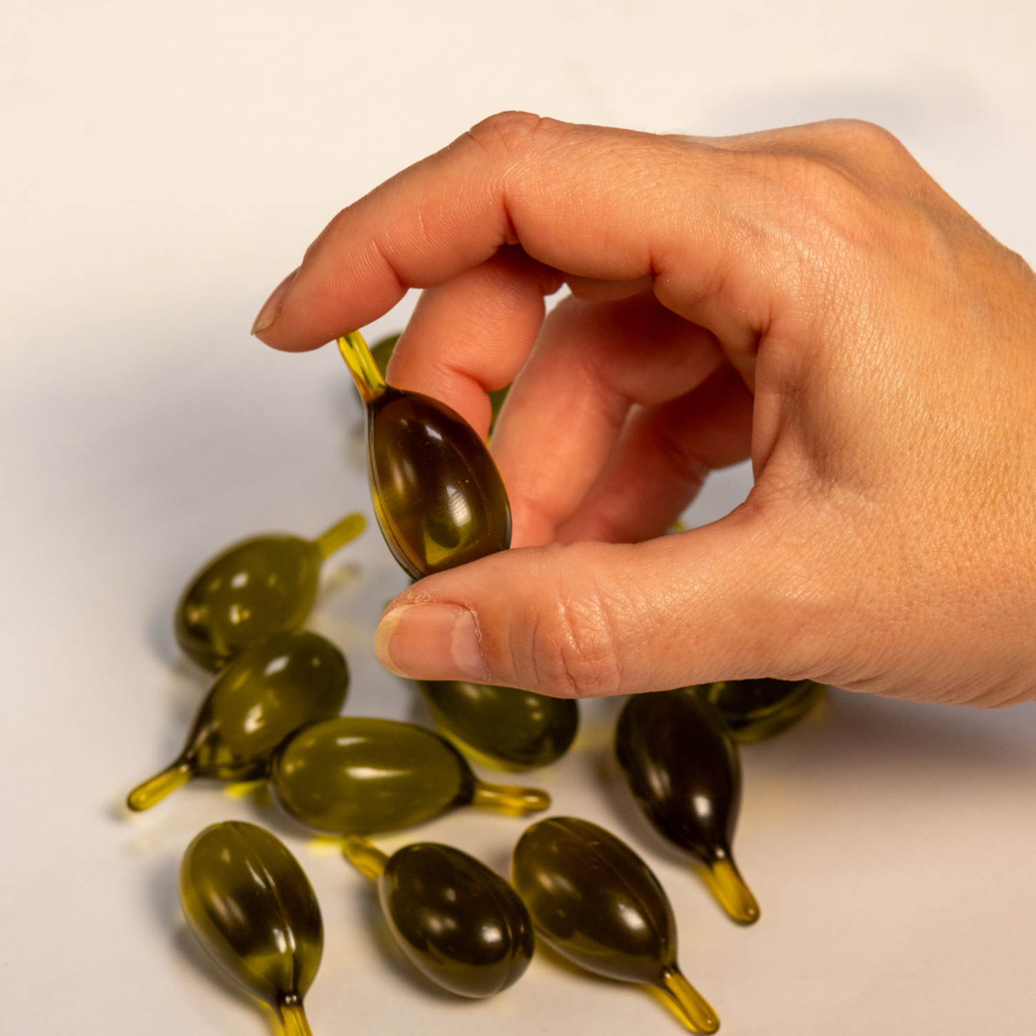 Hand holding an Oleaphen High Phenolic Olive Oil Pod